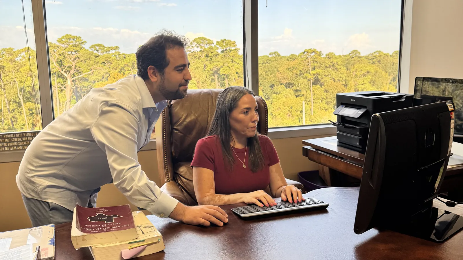 Dr. Medai Abadi in a working session with a client at her computer in Houston